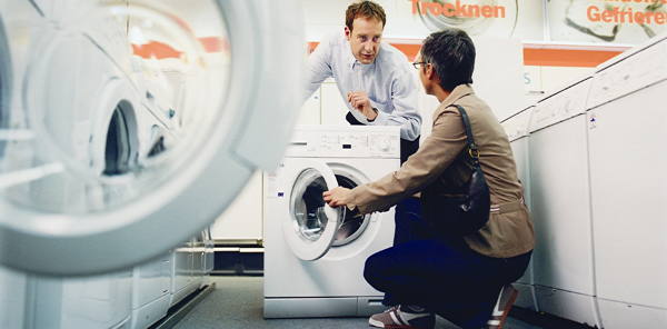 Verkäufer und Kundin mit Waschmaschine
